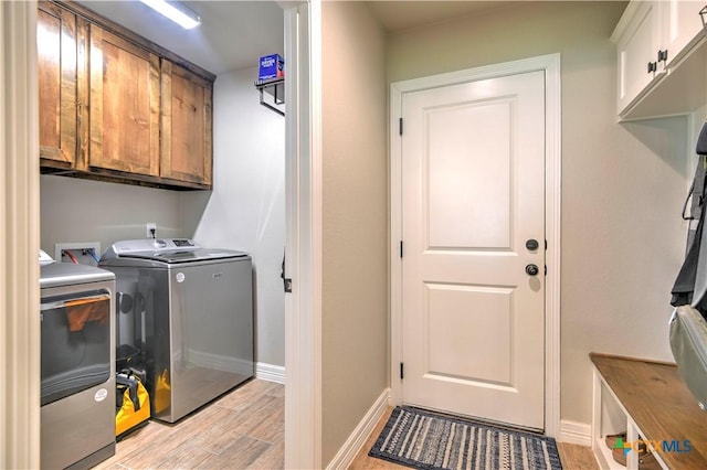 6129 Messina Dr, Temple, TX 76502 - laundry room featuring washer and clothes dryer, cabinet space, and light wood-style floors