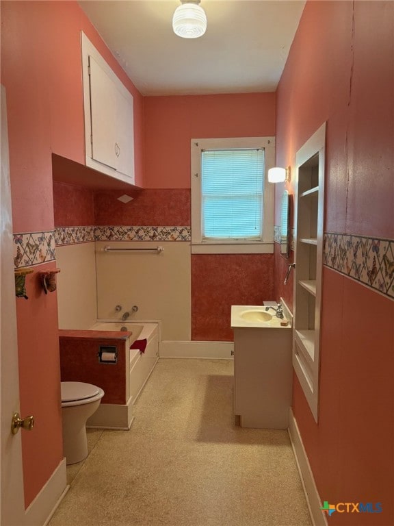 full bath featuring toilet, a tub to relax in, and vanity