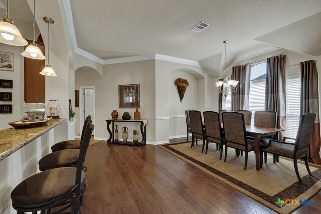 dining space with ornamental molding, a chandelier, dark wood-style floors, visible vents, and arched walkways