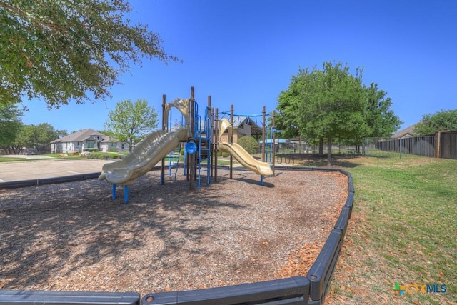 community playground featuring a yard and fence