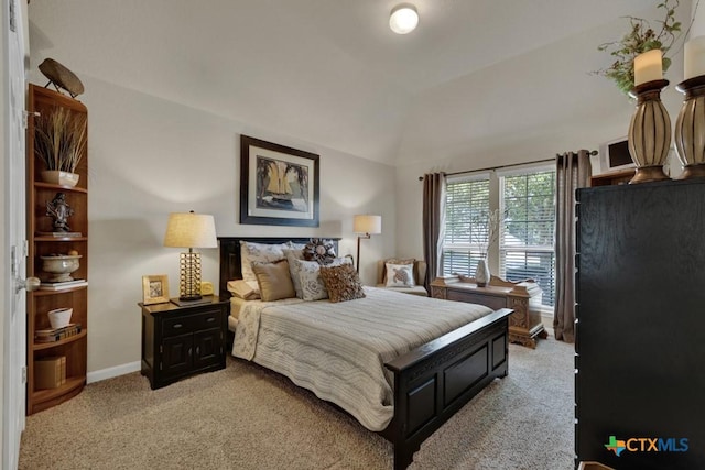 bedroom with baseboards, light colored carpet, and vaulted ceiling