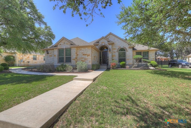 view of front facade with a front yard and stone siding