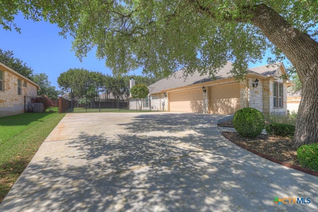 view of front of home with driveway, stone siding, central AC unit, a garage, and fence