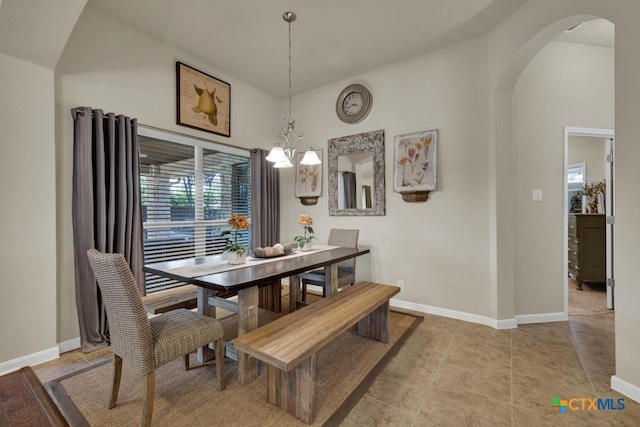 dining space with baseboards, arched walkways, a chandelier, and light tile patterned flooring