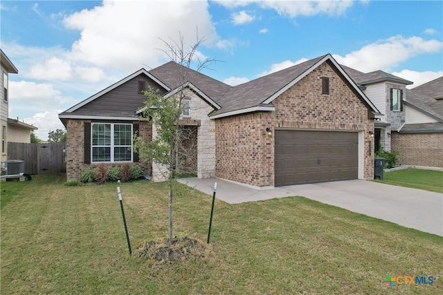 view of front of home with a front lawn, a garage, and central AC