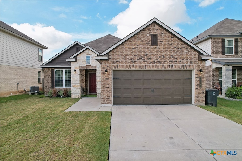 craftsman-style home featuring a front lawn, a garage, and central AC