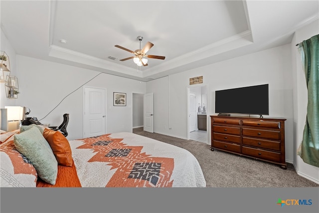 carpeted bedroom featuring connected bathroom, a tray ceiling, ceiling fan, and ornamental molding