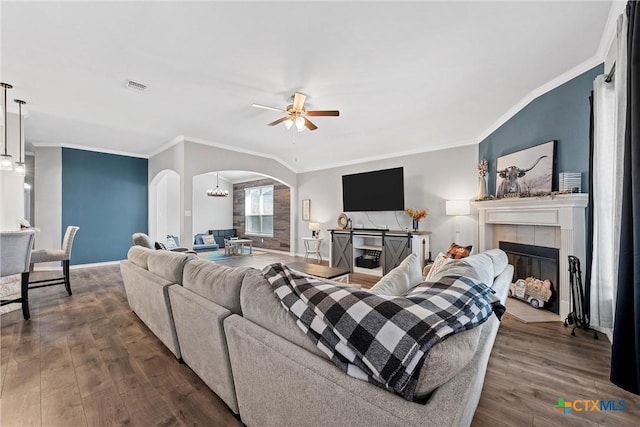 5502 Kent Dr, Belton, TX 76513 - living room with arched walkways, dark wood-style floors, ceiling fan, a tile fireplace, and ornamental molding