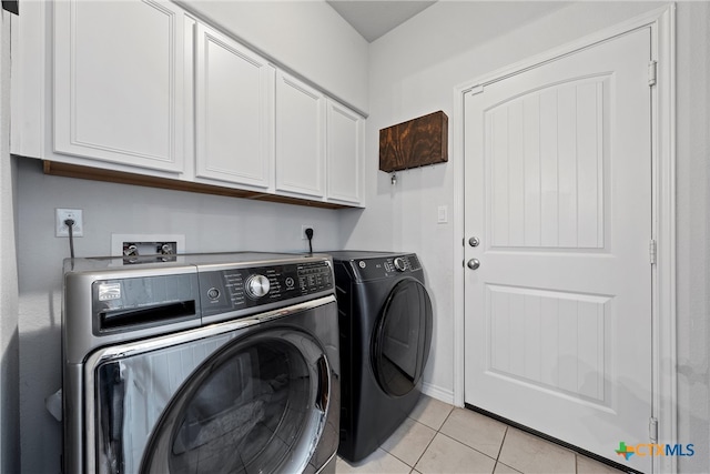 laundry room with cabinets, separate washer and dryer, and light tile patterned floors