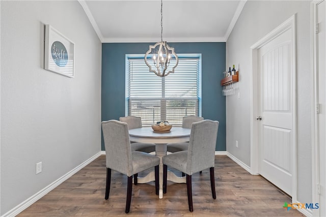 dining room featuring a notable chandelier, ornamental molding, and dark wood-type flooring