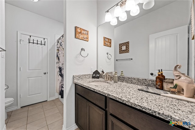 bathroom with tile patterned flooring, vanity, and toilet