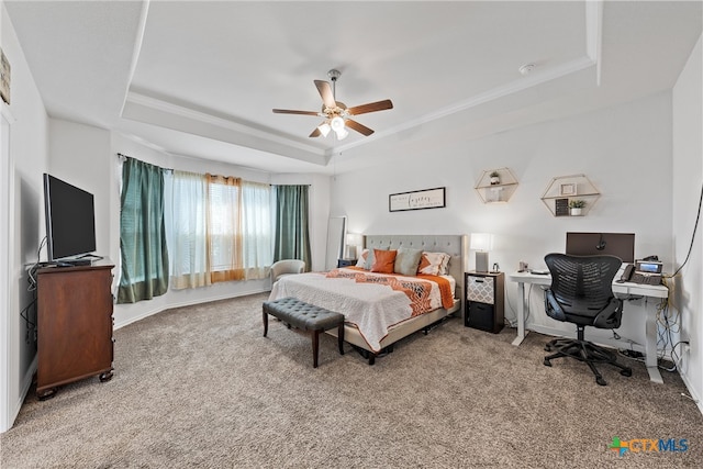 carpeted bedroom with ceiling fan, a raised ceiling, and crown molding