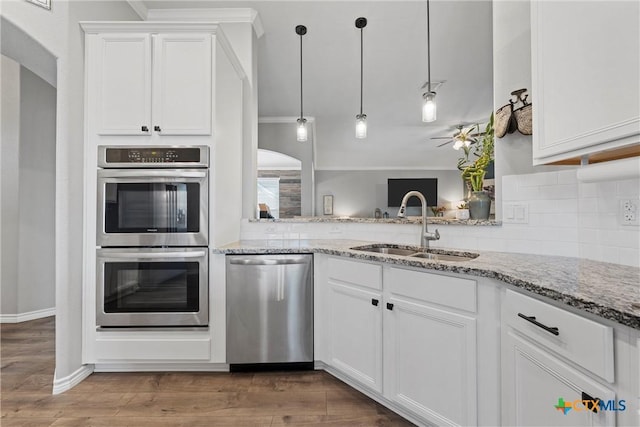 5502 Kent Dr, Belton, TX 76513 - kitchen with appliances with stainless steel finishes, backsplash, light stone counters, white cabinetry, and crown molding