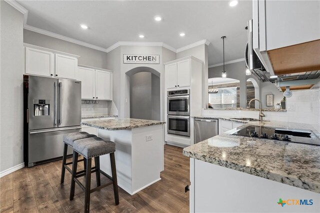 5502 Kent Dr, Belton, TX 76513 - kitchen featuring appliances with stainless steel finishes, ornamental molding, light stone countertops, recessed lighting, and white cabinets