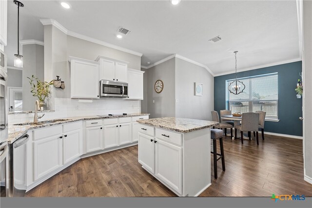 kitchen featuring sink, hanging light fixtures, appliances with stainless steel finishes, and dark wood-type flooring