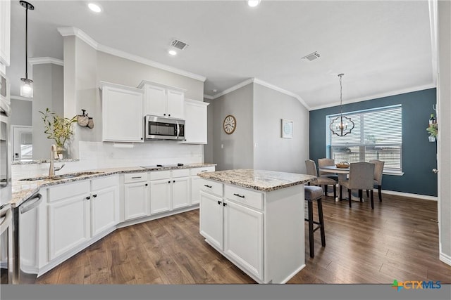 5502 Kent Dr, Belton, TX 76513 - kitchen with stainless steel appliances, crown molding, dark wood-type flooring, tasteful backsplash, and a chandelier