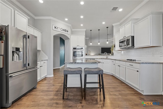 5502 Kent Dr, Belton, TX 76513 - kitchen with stainless steel appliances, arched walkways, crown molding, white cabinetry, and recessed lighting
