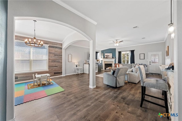 5502 Kent Dr, Belton, TX 76513 - living room with a chandelier, arched walkways, dark wood-style floors, a ceiling fan, and a fireplace