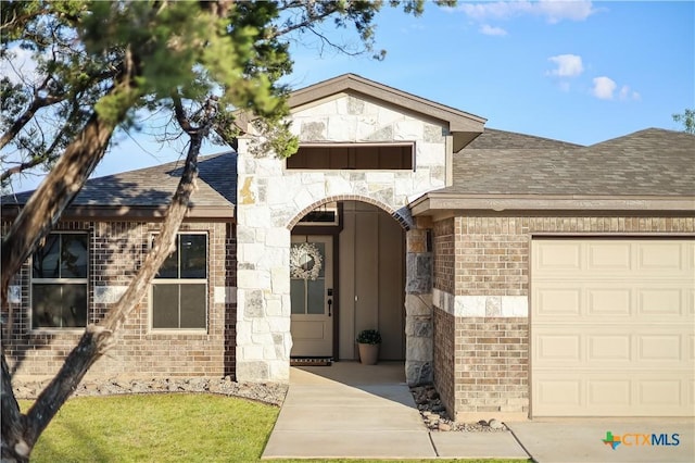 view of front of property with brick siding, roof with shingles, and a garage