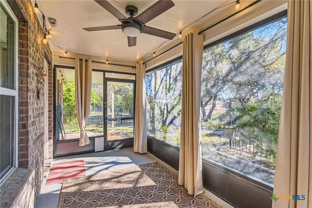 unfurnished sunroom with ceiling fan