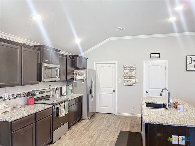 kitchen with tasteful backsplash, ornamental molding, appliances with stainless steel finishes, sink, and vaulted ceiling