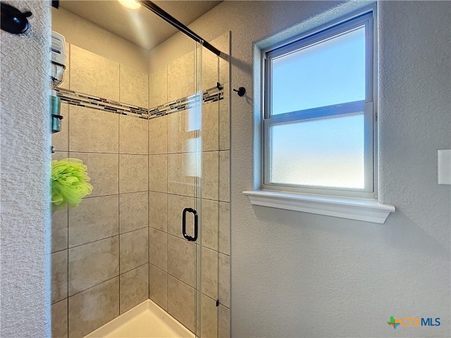 bathroom featuring a shower with door