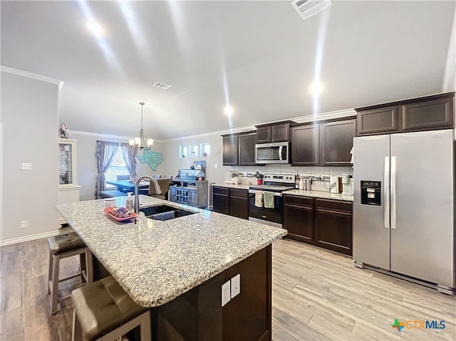 kitchen with sink, an island with sink, crown molding, and stainless steel appliances