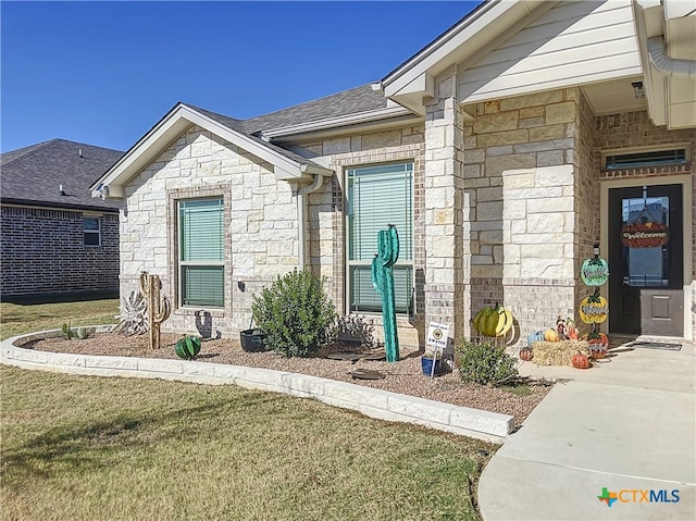 entrance to property featuring a lawn