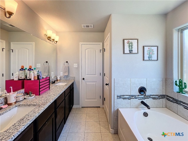 bathroom featuring a washtub, vanity, and tile patterned floors