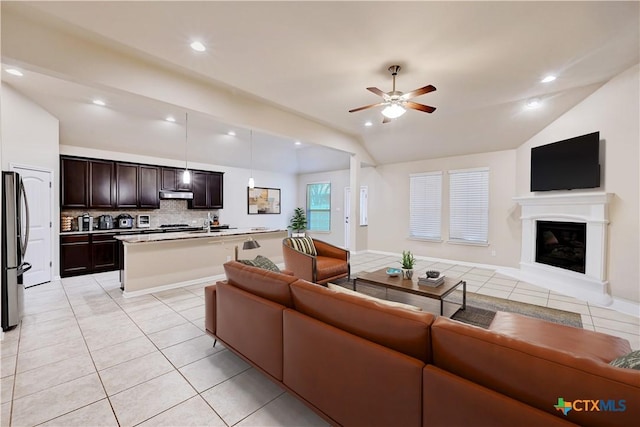 834 Oyster Crk, Buda, TX 78610 - living area with lofted ceiling, light tile patterned floors, a ceiling fan, a glass covered fireplace, and recessed lighting