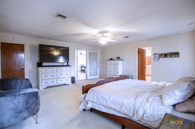 carpeted bedroom with ceiling fan, a textured ceiling, and ensuite bath