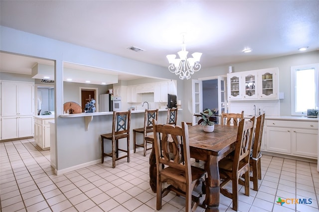 dining space with light tile patterned flooring and an inviting chandelier