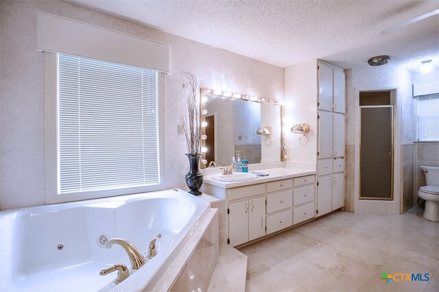 full bathroom with plus walk in shower, vanity, a textured ceiling, and toilet