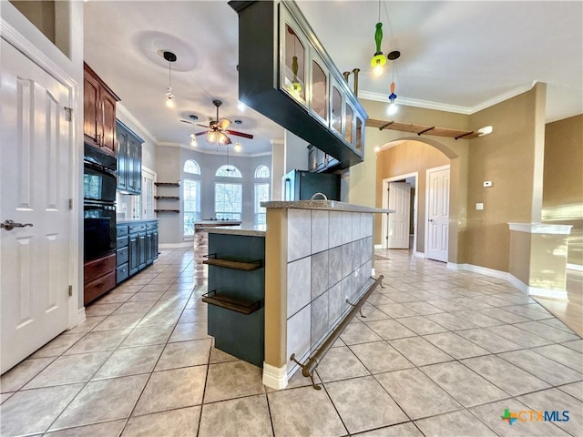 kitchen with stainless steel fridge, kitchen peninsula, ceiling fan, light tile patterned flooring, and crown molding