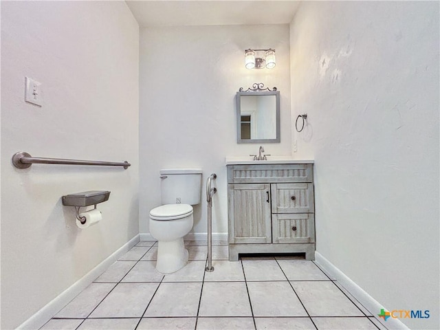 bathroom with toilet, tile patterned floors, and vanity