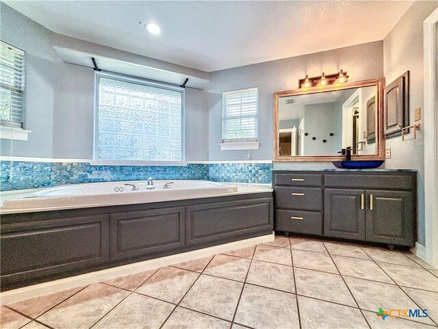 bathroom with a bathing tub, tile patterned flooring, and vanity