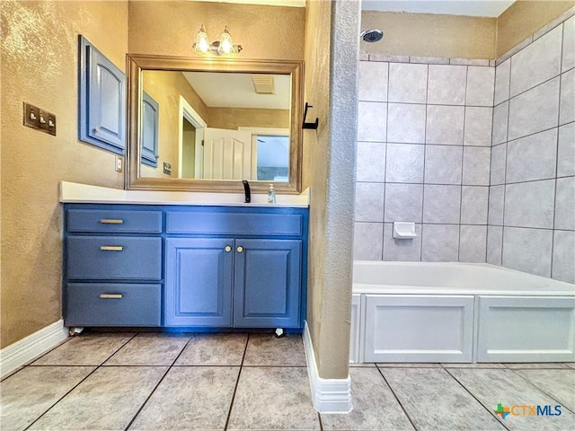 bathroom with tile patterned flooring, tiled shower / bath combo, and vanity