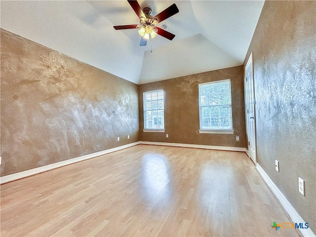 spare room featuring ceiling fan, light wood-type flooring, and vaulted ceiling