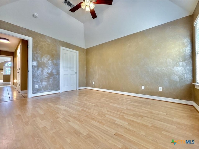 empty room featuring light wood-type flooring, ceiling fan, and high vaulted ceiling