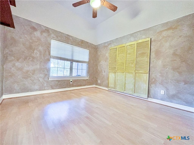 unfurnished bedroom featuring ceiling fan, lofted ceiling, and light wood-type flooring