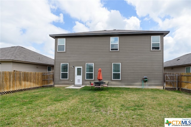 rear view of property with a yard and a patio area