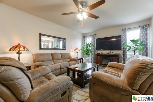 living room featuring a wealth of natural light, ceiling fan, and light colored carpet