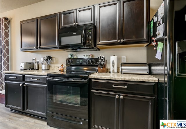 kitchen with dark brown cabinets, light hardwood / wood-style flooring, and black appliances