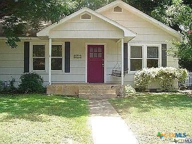 view of front of house with a porch and a front yard