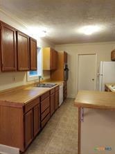 kitchen featuring light countertops, a sink, and freestanding refrigerator