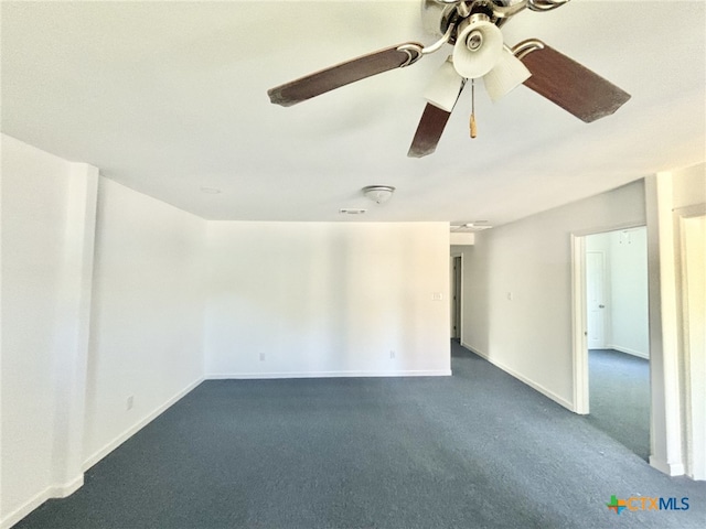 spare room featuring ceiling fan and dark carpet