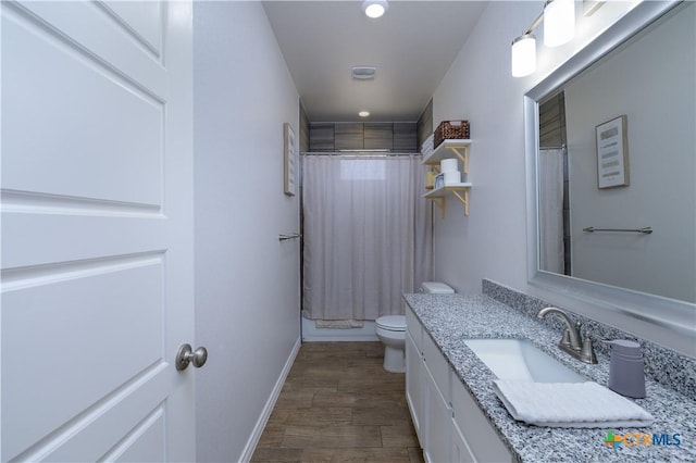 bathroom featuring curtained shower, toilet, wood finished floors, vanity, and baseboards