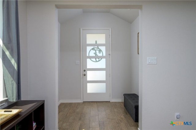 entryway featuring vaulted ceiling, wood finished floors, a wealth of natural light, and baseboards