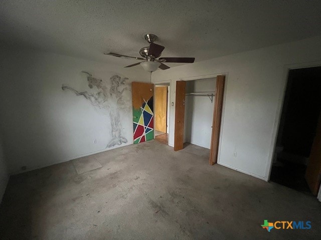 unfurnished bedroom featuring ceiling fan, a closet, concrete flooring, and a textured ceiling