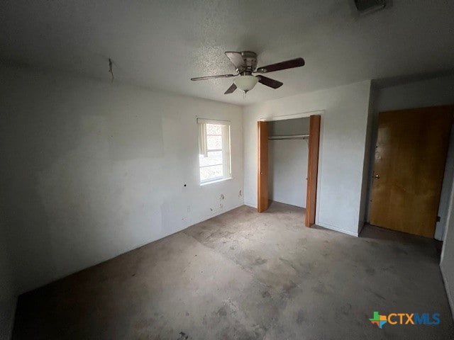 unfurnished bedroom featuring ceiling fan and a closet